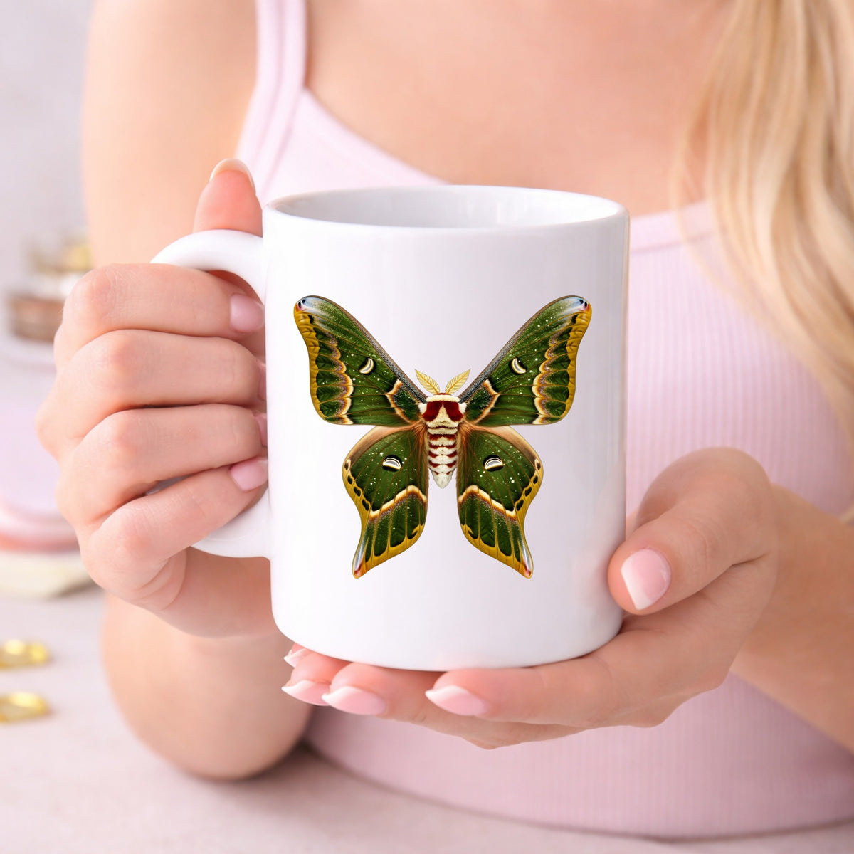 Olive Green Moth UV DTF sticker applied to a white coffee mug held in both hands