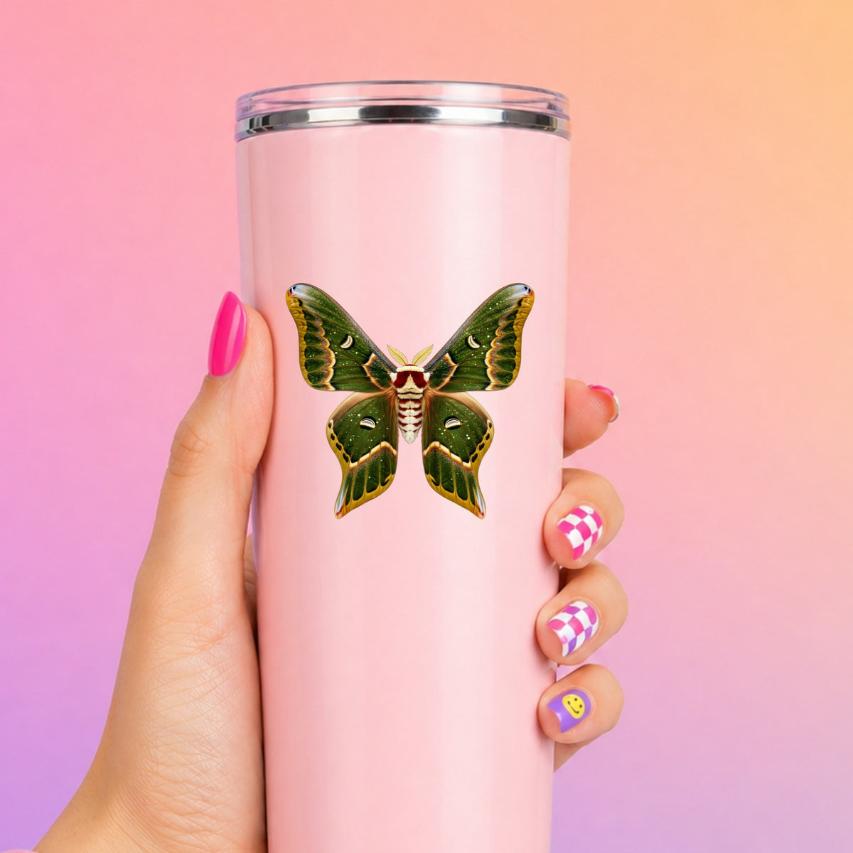 Olive Green Moth UV DTF sticker applied to a tall pink tumbler on a pink and orange background