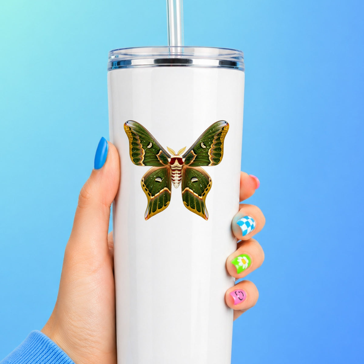 Olive Green Moth UV DTF sticker applied to a white straw tumbler on a blue background