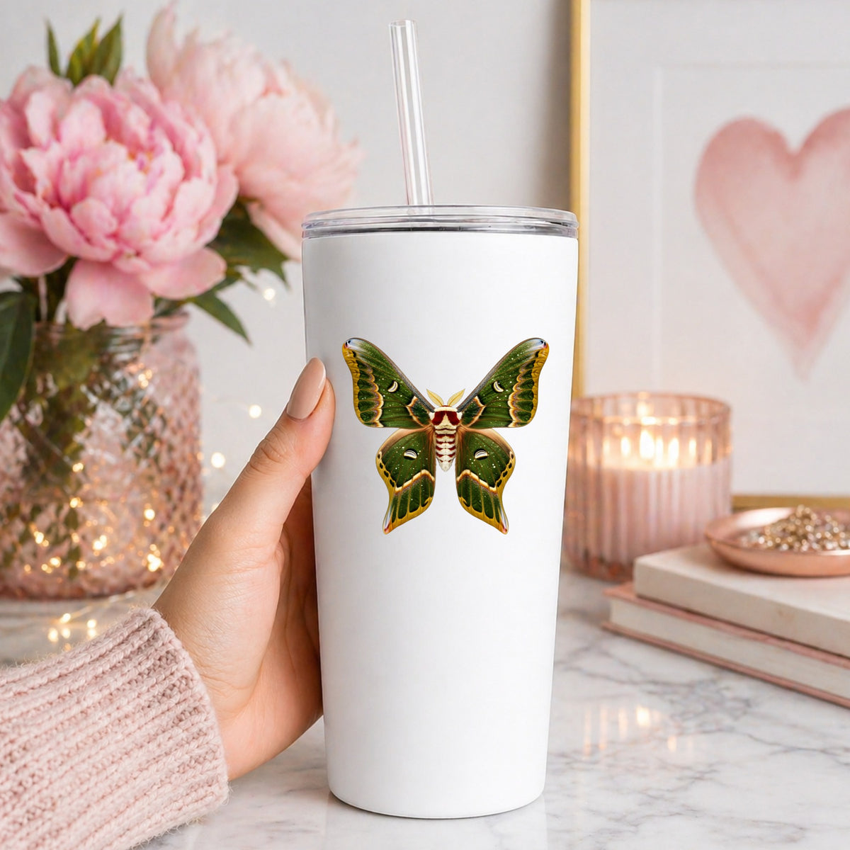 Olive Green Moth UV DTF sticker applied to a white straw tumbler beside pink peonies