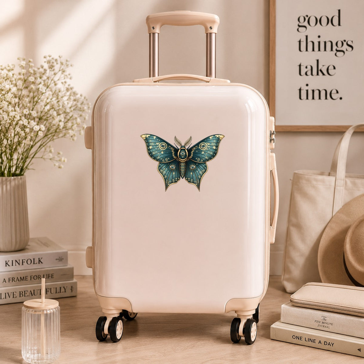Teal Rune Moth All Seeing Eye UV DTF sticker applied to a cream carry-on suitcase