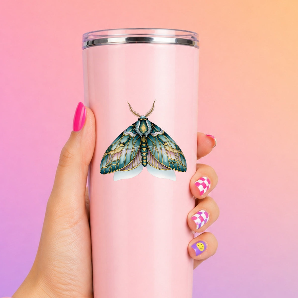 Pastel Teal Pink Moth UV DTF sticker applied to a tall pink tumbler on a pink and orange background