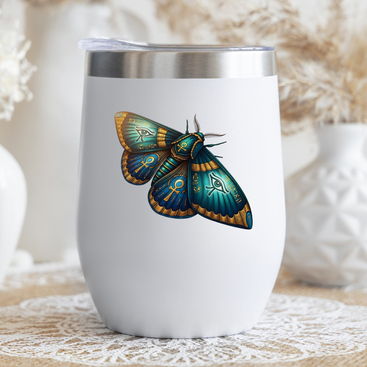 Egyptian Eye Of Horus Moth UV DTF sticker applied to a white stemless tumbler with a lid