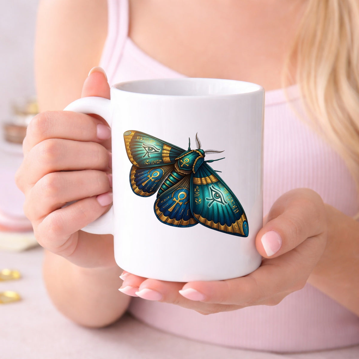 Egyptian Eye Of Horus Moth UV DTF sticker applied to a white coffee mug held in both hands