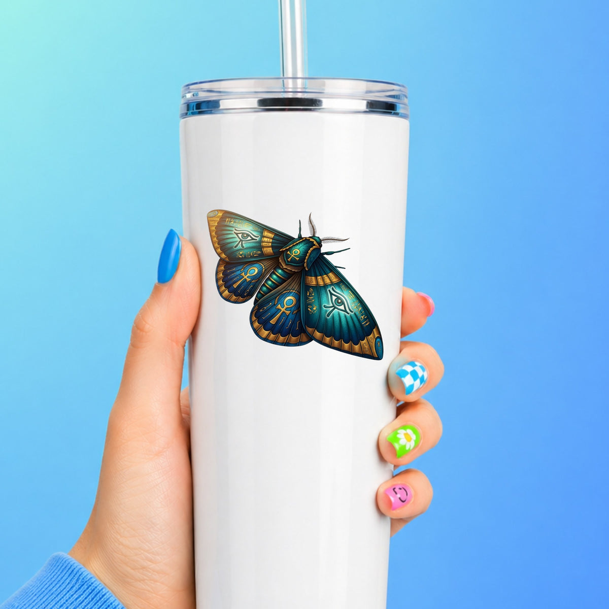 Egyptian Eye Of Horus Moth UV DTF sticker applied to a white straw tumbler on a blue background