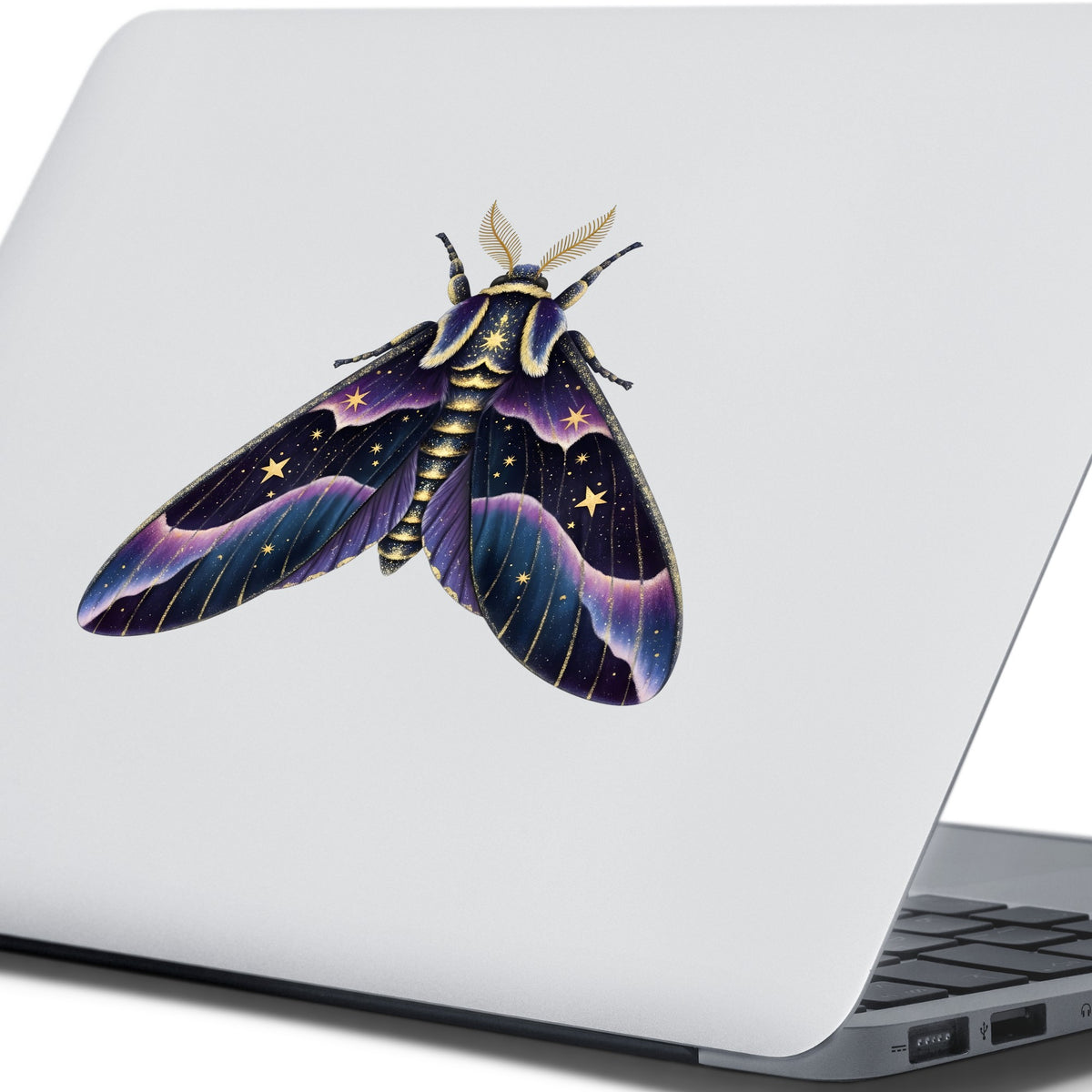 Night Sky Purple Moth UV DTF sticker applied to the lid of a silver laptop