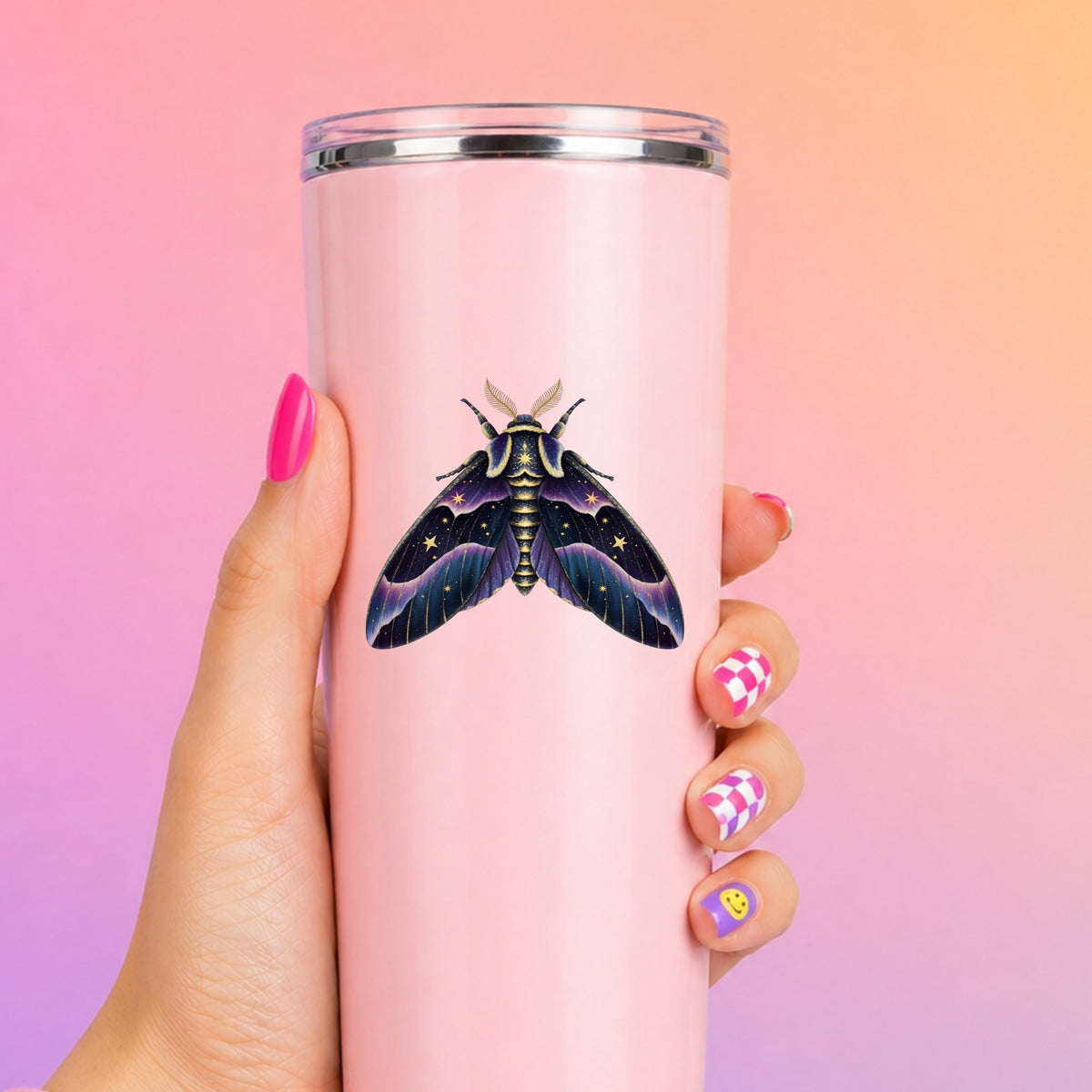 Night Sky Purple Moth UV DTF sticker applied to a tall pink tumbler on a pink and orange background