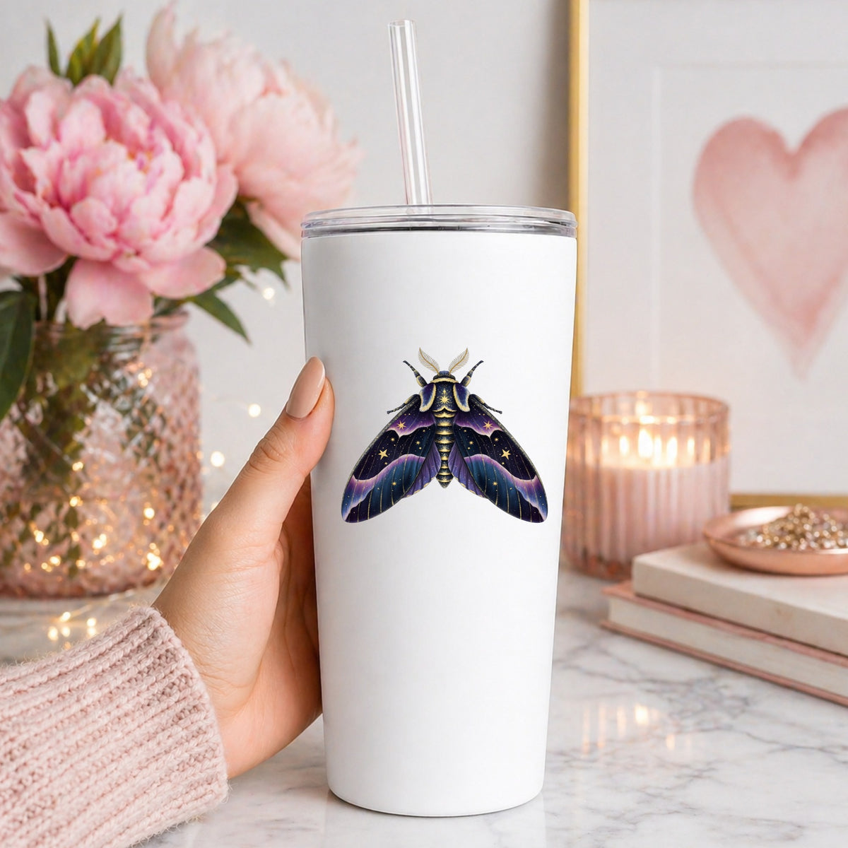 Night Sky Purple Moth UV DTF sticker applied to a white straw tumbler beside pink peonies