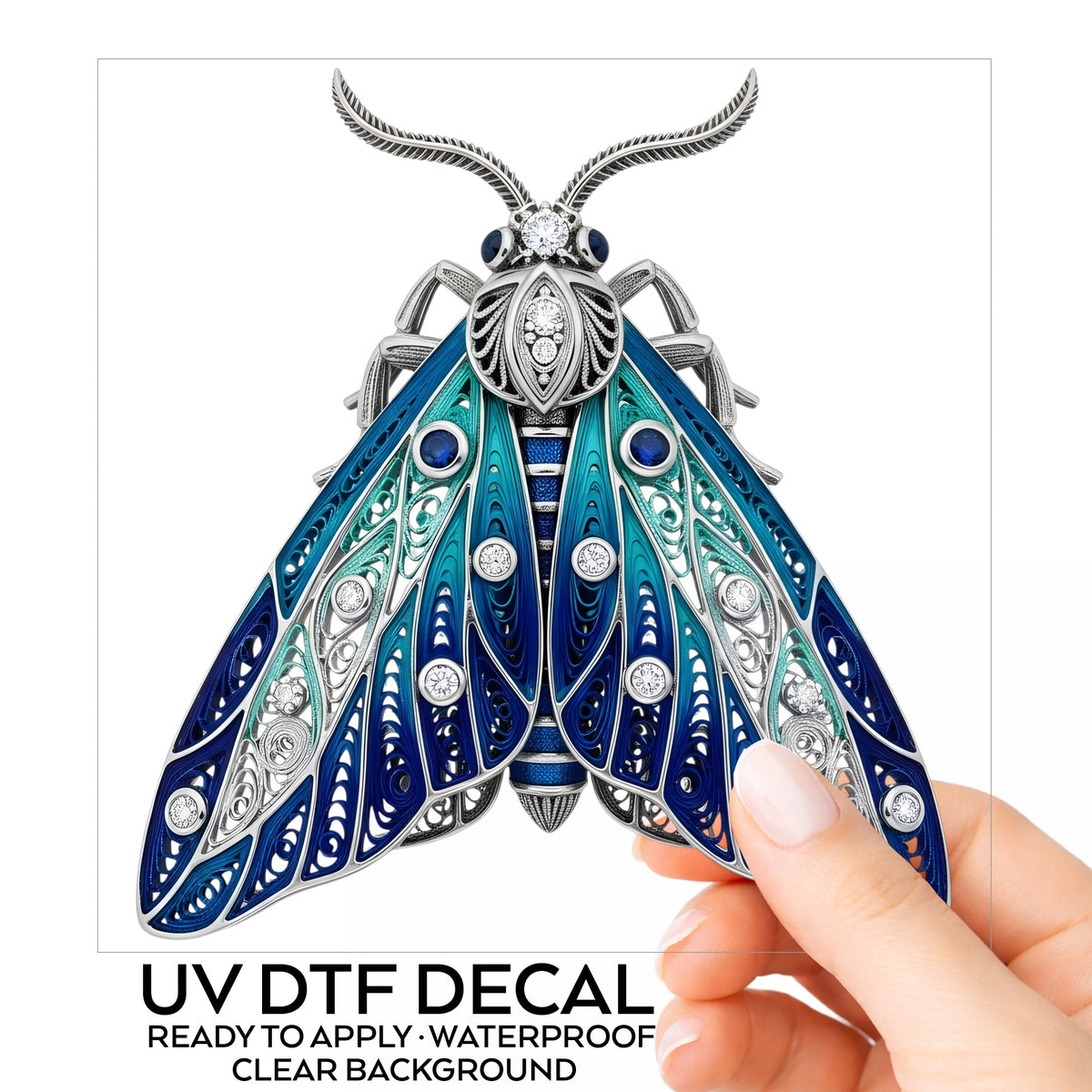 Silver Filigree Blue Moth UV DTF sticker on its backing card, held in hand