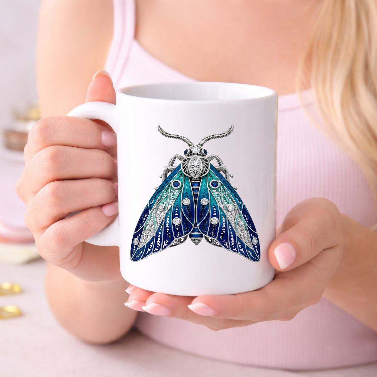 Silver Filigree Blue Moth UV DTF sticker applied to a white coffee mug held in both hands