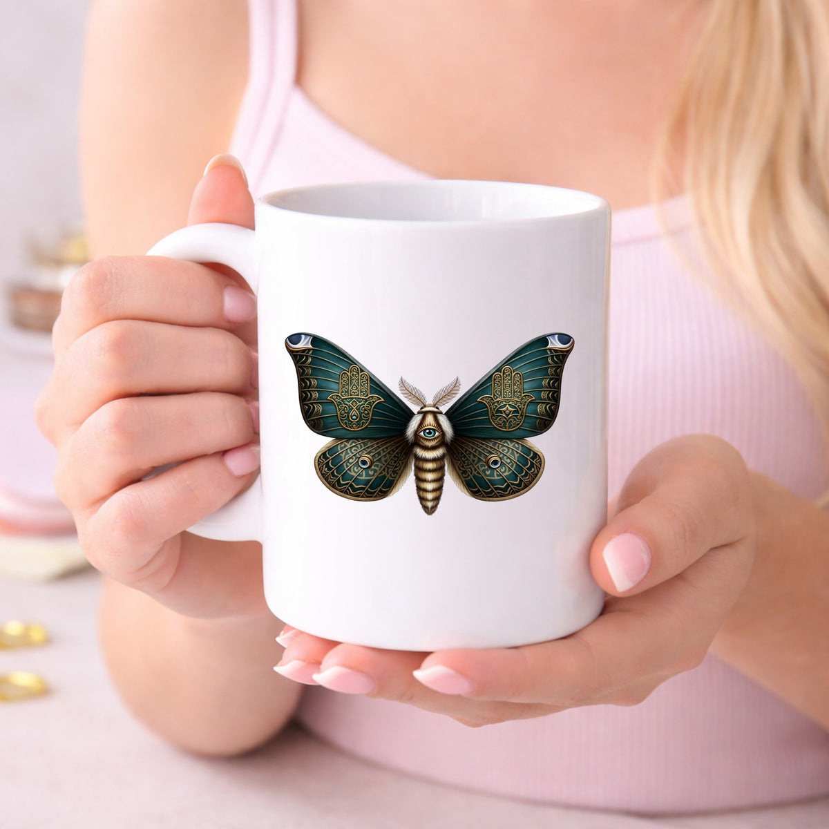 Hamsa Hand Moth UV DTF sticker applied to a white coffee mug held in both hands
