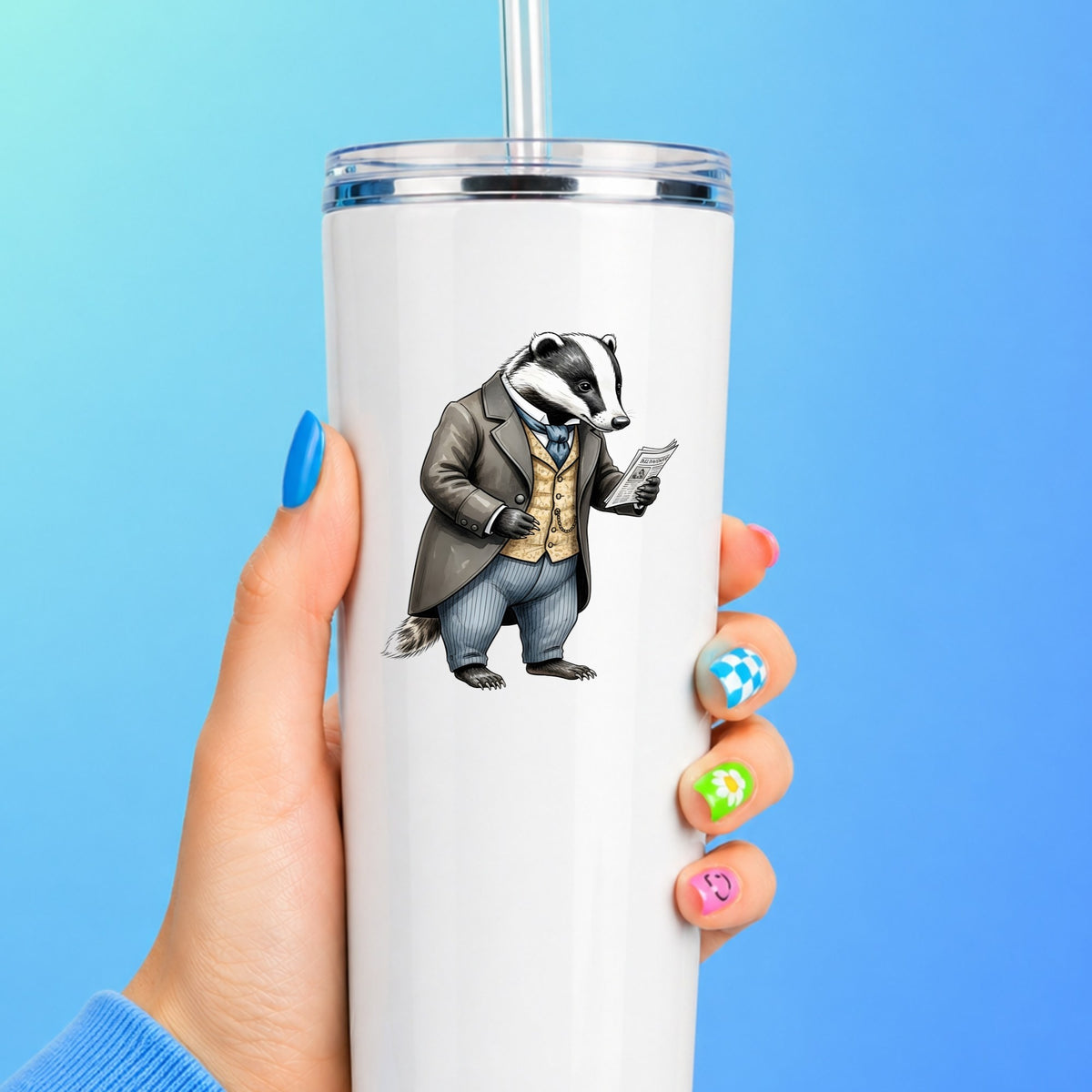 Badger Reading Newspaper UV DTF sticker applied to a white straw tumbler on a blue background
