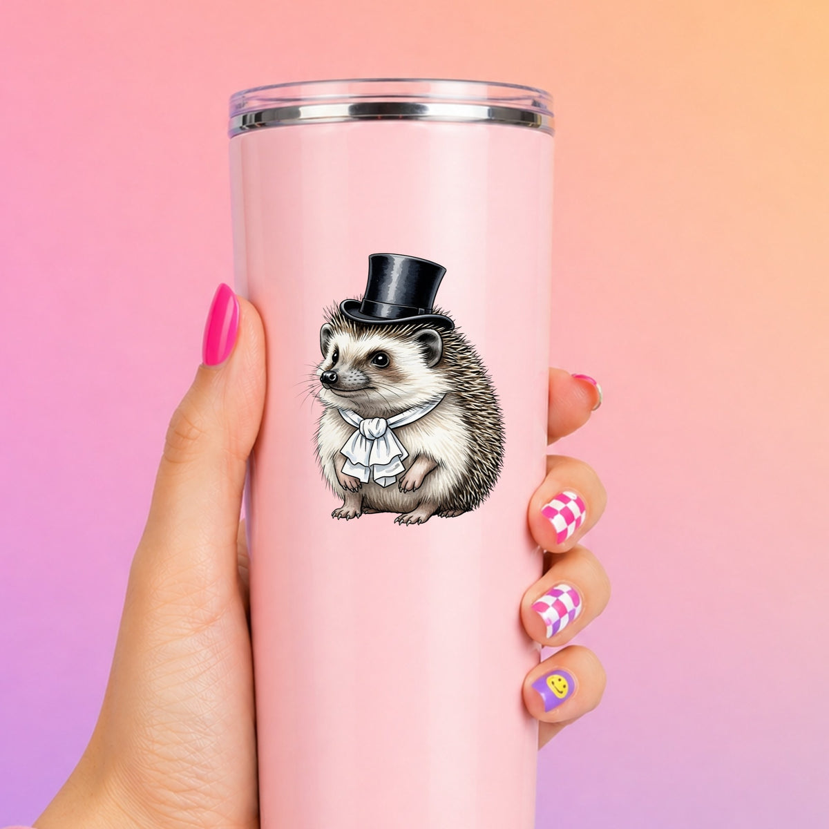 Hedgehog In Top Hat UV DTF sticker applied to a tall pink tumbler on a pink and orange background