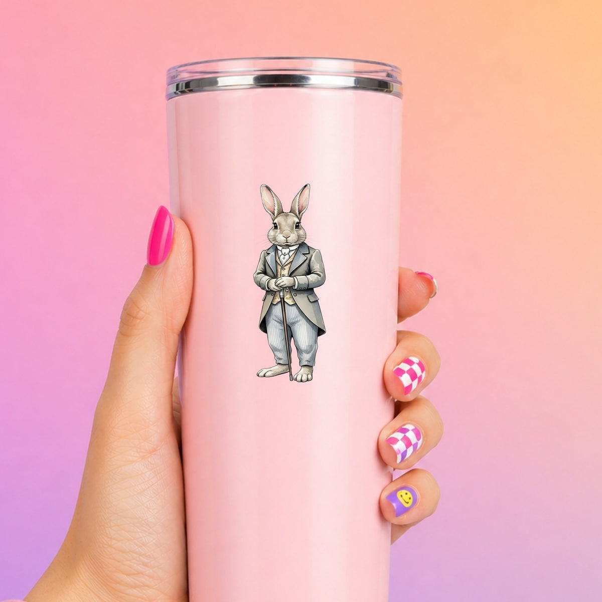 Gray Bunny Victorian Suit Cane UV DTF sticker applied to a tall pink tumbler on a pink and orange background