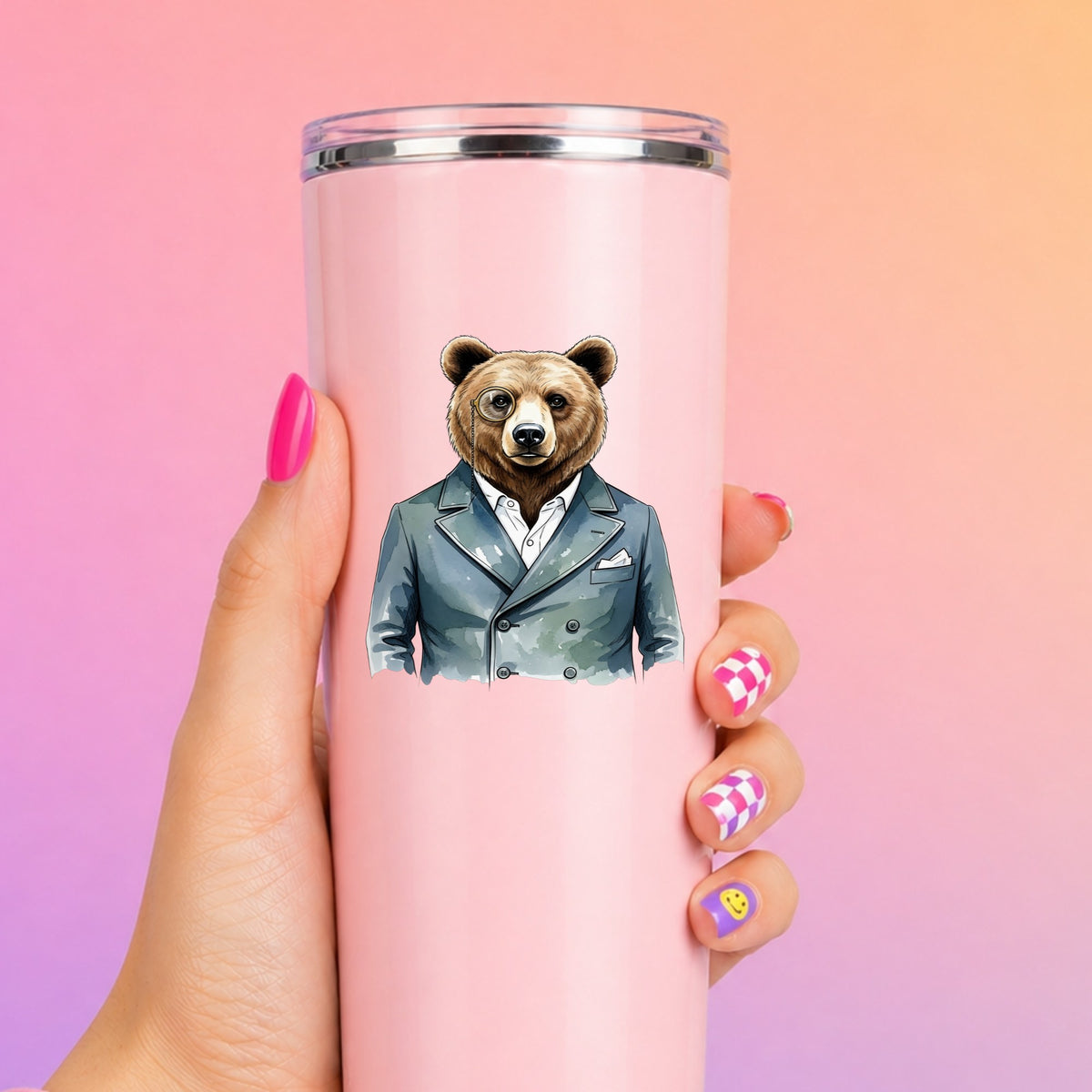 Bear With Monocle Blue Suit UV DTF sticker applied to a tall pink tumbler on a pink and orange background