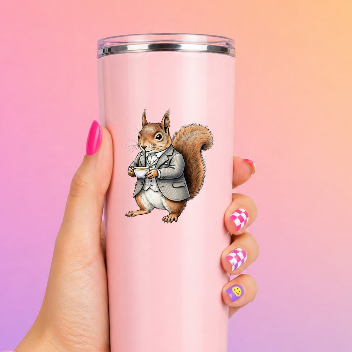 Red Squirrel Holding Teacup UV DTF sticker applied to a tall pink tumbler on a pink and orange background
