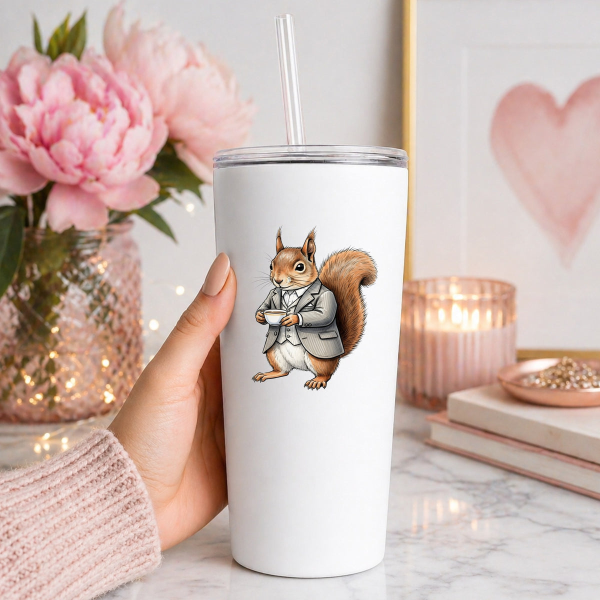 Red Squirrel Holding Teacup UV DTF sticker applied to a white straw tumbler beside pink peonies