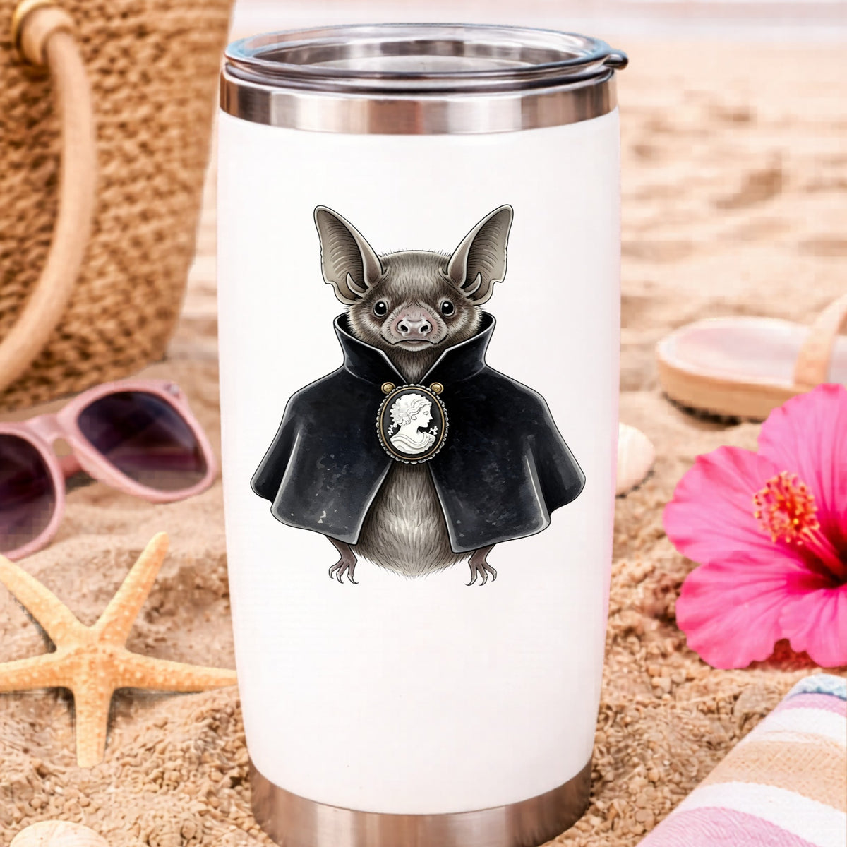 Bat In Black Cape Cameo UV DTF sticker applied to a white travel tumbler on beach sand