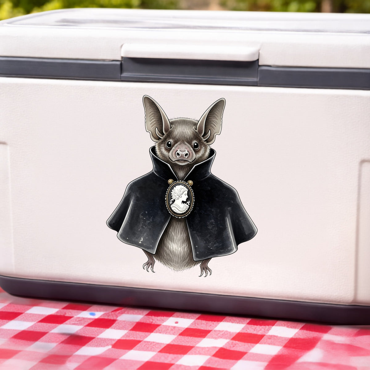Bat In Black Cape Cameo UV DTF sticker applied to a white cooler on a red gingham cloth