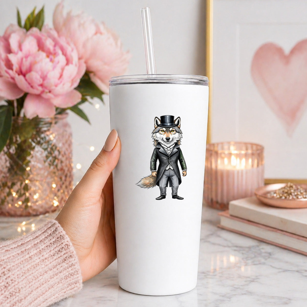 Gray Wolf Top Hat Tailcoat UV DTF sticker applied to a white straw tumbler beside pink peonies