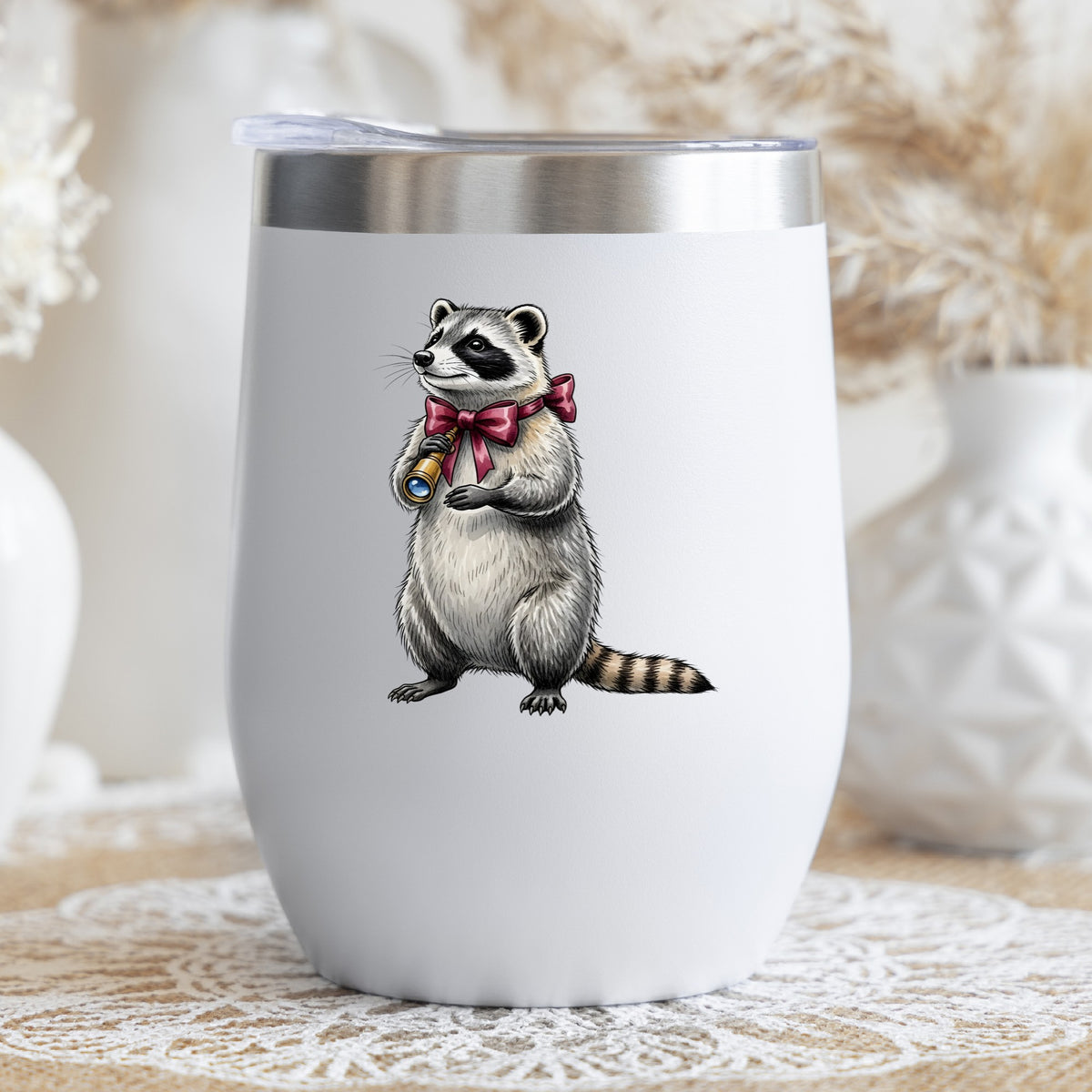 Raccoon With Spyglass Red Bow UV DTF sticker applied to a white stemless tumbler with a lid