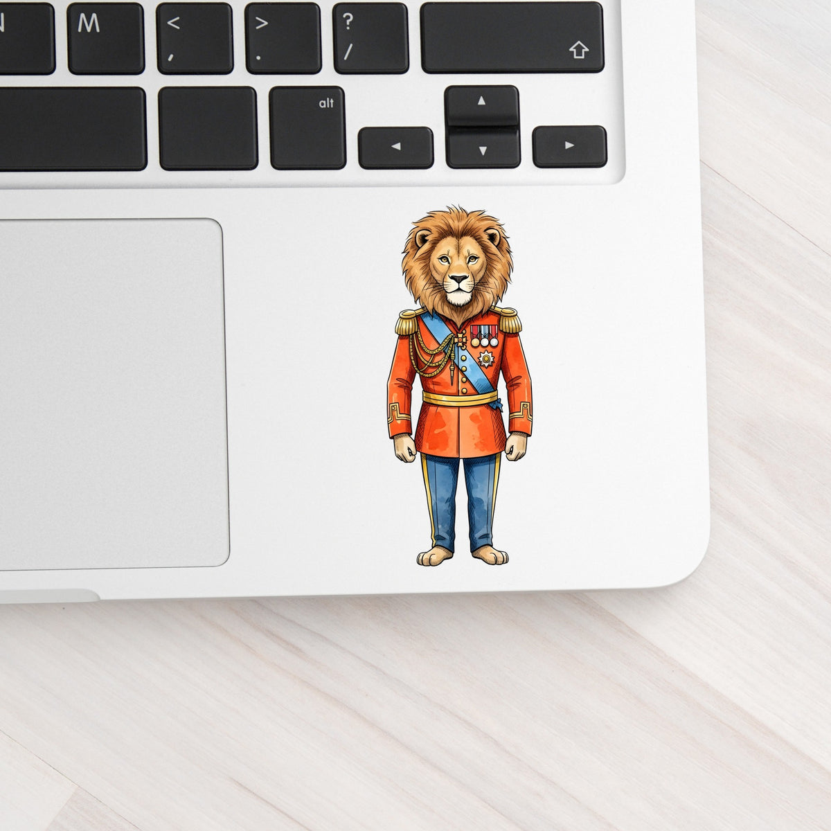 Lion Red Military Uniform UV DTF sticker applied to a silver laptop beside the keyboard