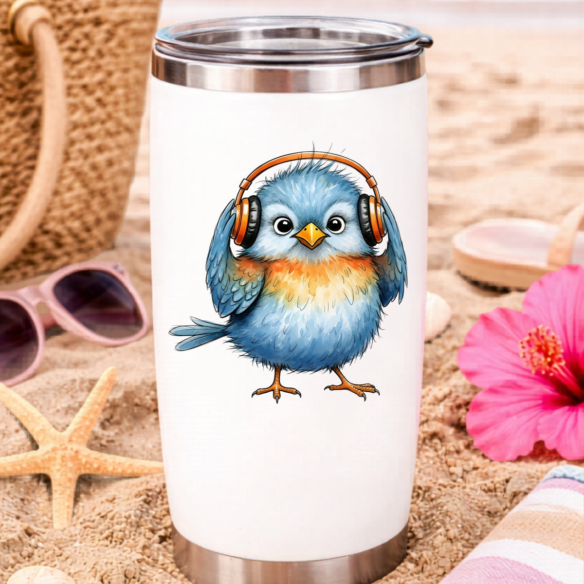 Blue Bird With Headphones UV DTF sticker applied to a white travel tumbler on beach sand