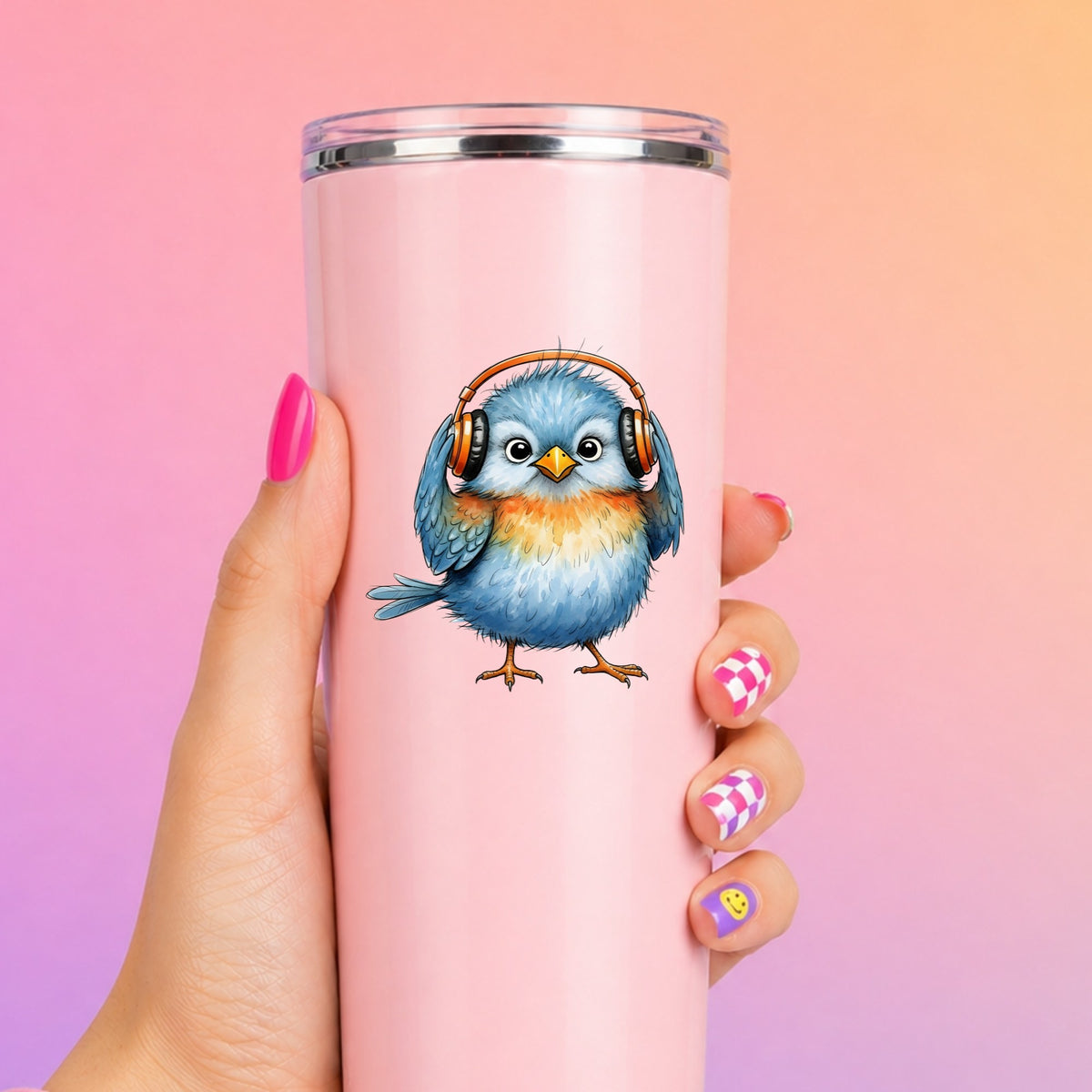 Blue Bird With Headphones UV DTF sticker applied to a tall pink tumbler on a pink and orange background