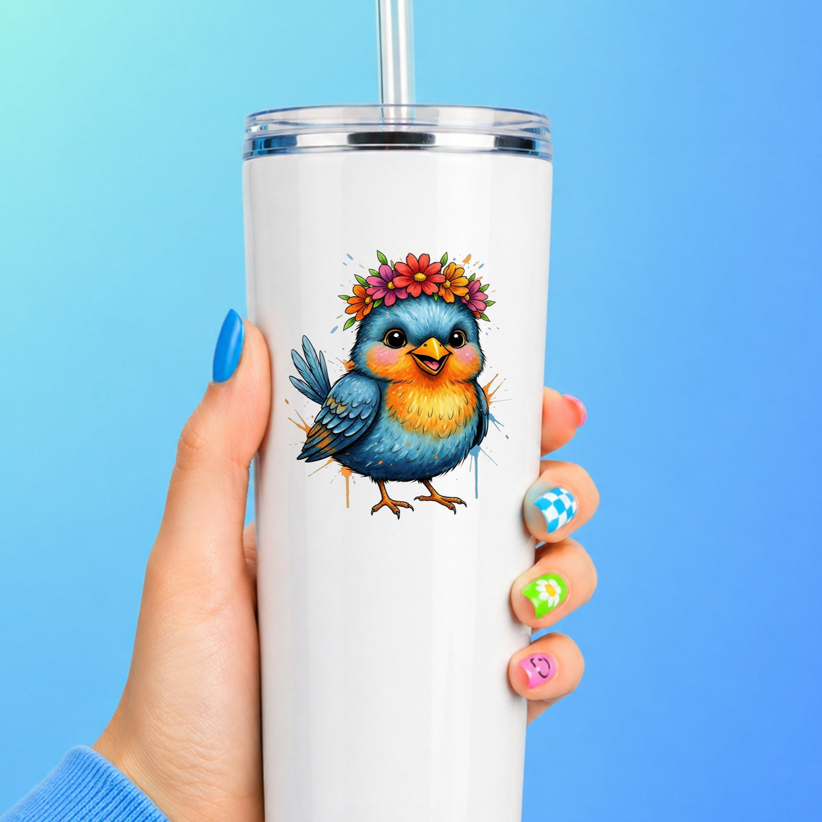 Flower Crown Blue Bird UV DTF sticker applied to a white straw tumbler on a blue background