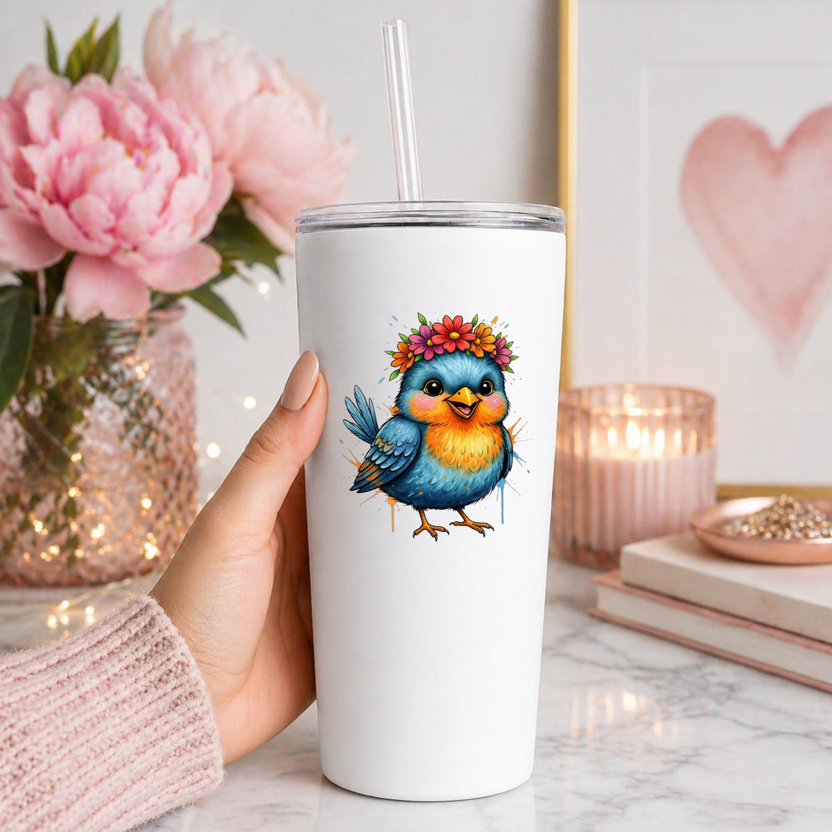Flower Crown Blue Bird UV DTF sticker applied to a white straw tumbler beside pink peonies