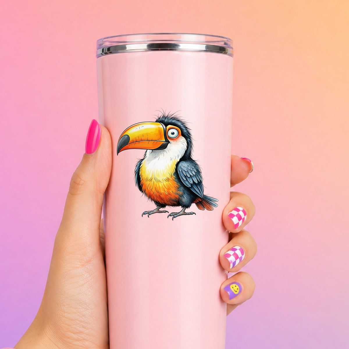 Toucan Big Orange Beak UV DTF sticker applied to a tall pink tumbler on a pink and orange background
