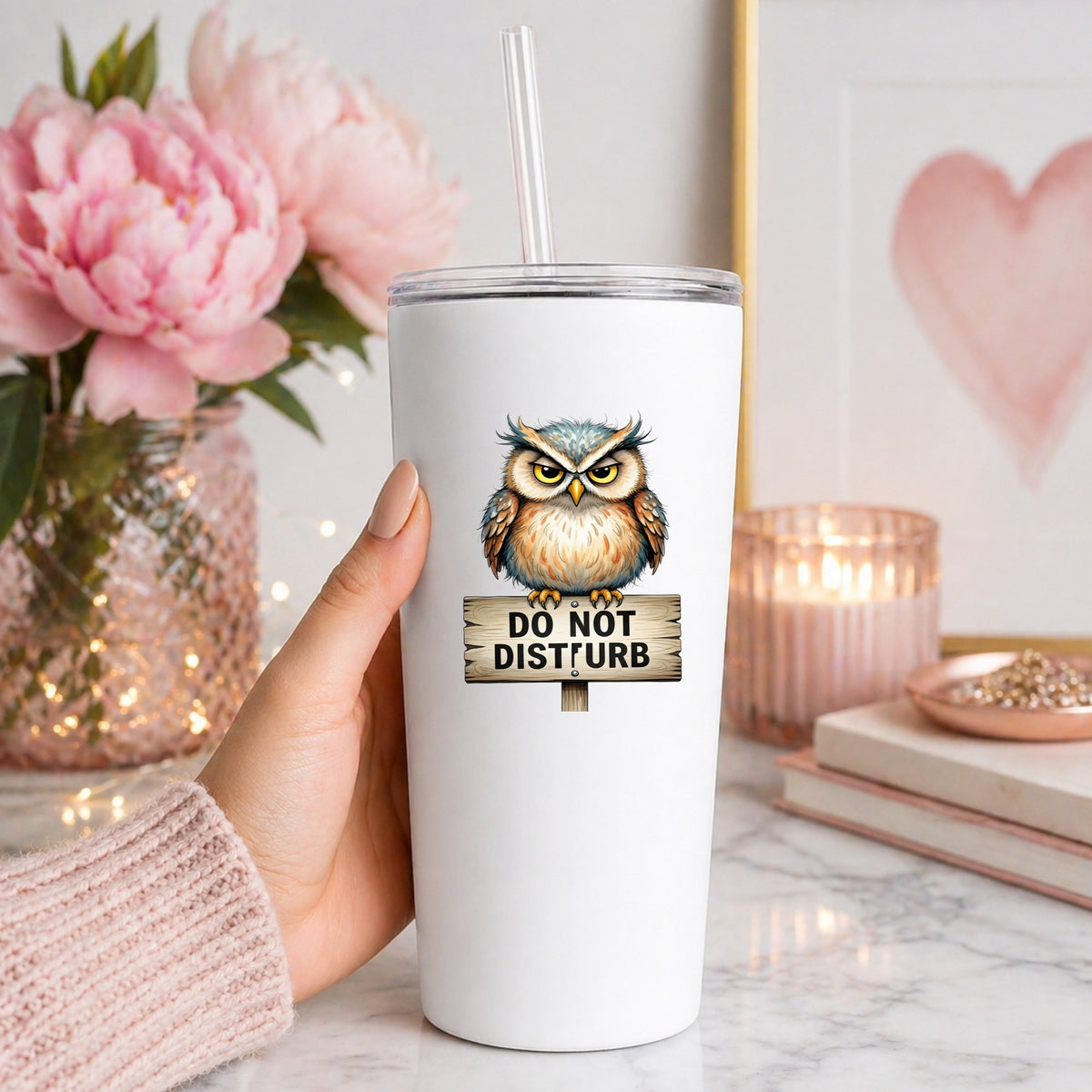 Grumpy Owl Do Not Disturb Sign UV DTF sticker applied to a white straw tumbler beside pink peonies