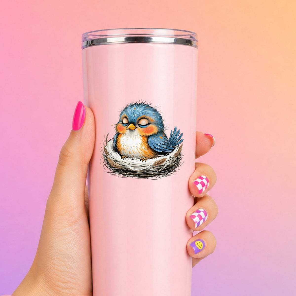 Sleeping Bird In Nest UV DTF sticker applied to a tall pink tumbler on a pink and orange background