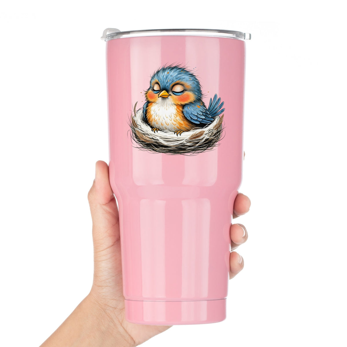 Sleeping Bird In Nest UV DTF sticker applied to a pink tumbler held against a white background