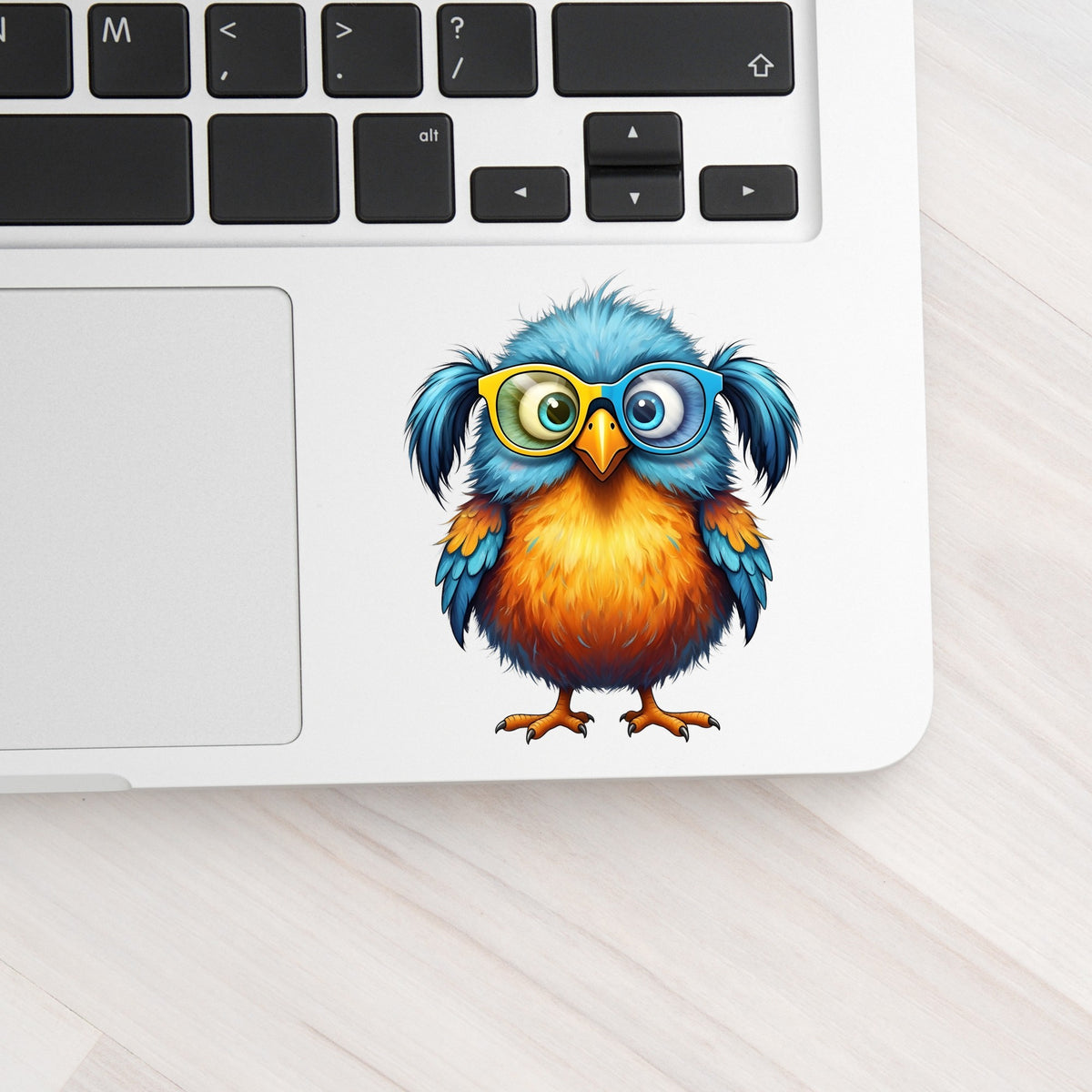 Bird With Big Yellow Glasses Pigtails UV DTF sticker applied to a silver laptop beside the keyboard