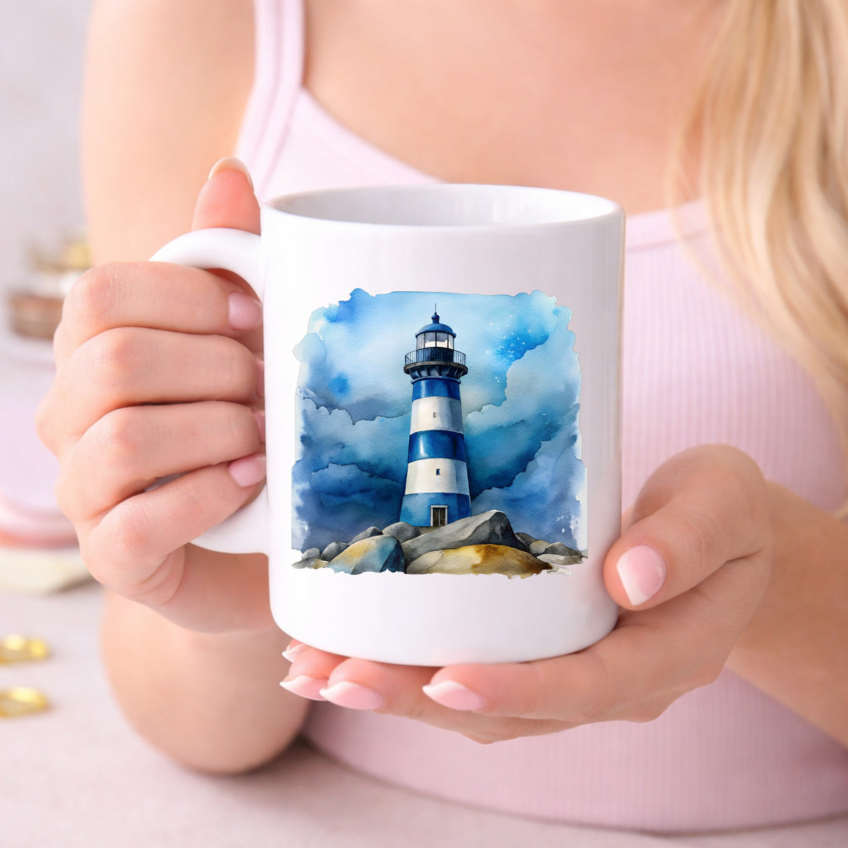 Blue Striped Lighthouse On Rocks UV DTF sticker applied to a white coffee mug held in both hands