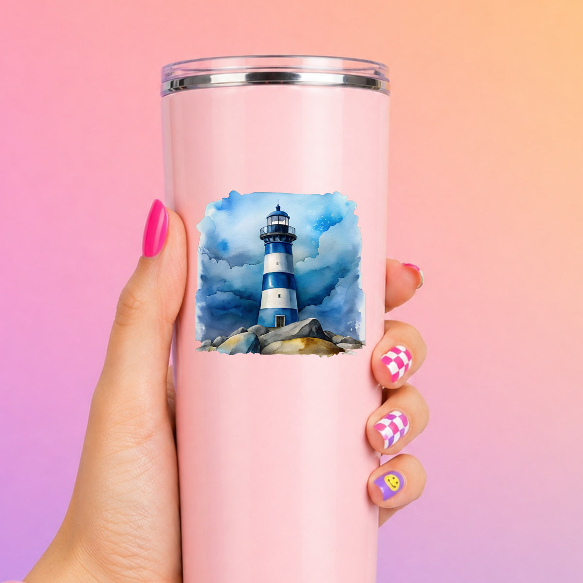 Blue Striped Lighthouse On Rocks UV DTF sticker applied to a tall pink tumbler on a pink and orange background