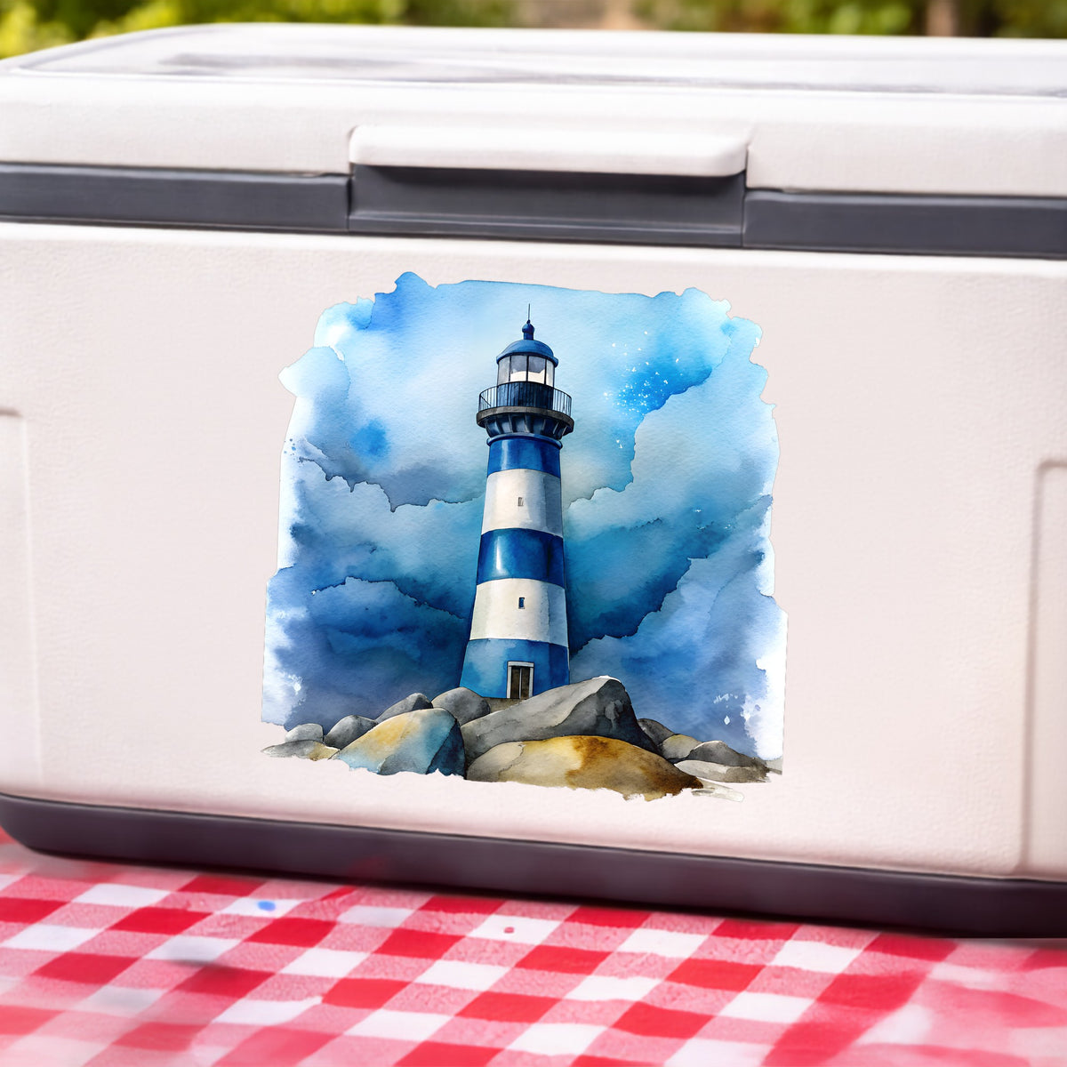 Blue Striped Lighthouse On Rocks UV DTF sticker applied to a white cooler on a red gingham cloth