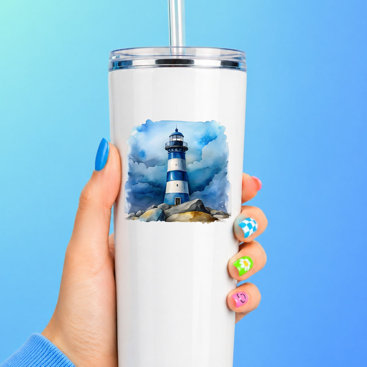 Blue Striped Lighthouse On Rocks UV DTF sticker applied to a white straw tumbler on a blue background