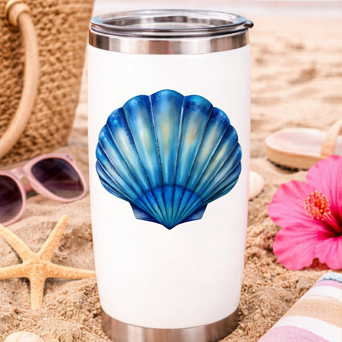 Blue Scallop Seashell UV DTF sticker applied to a white travel tumbler on beach sand