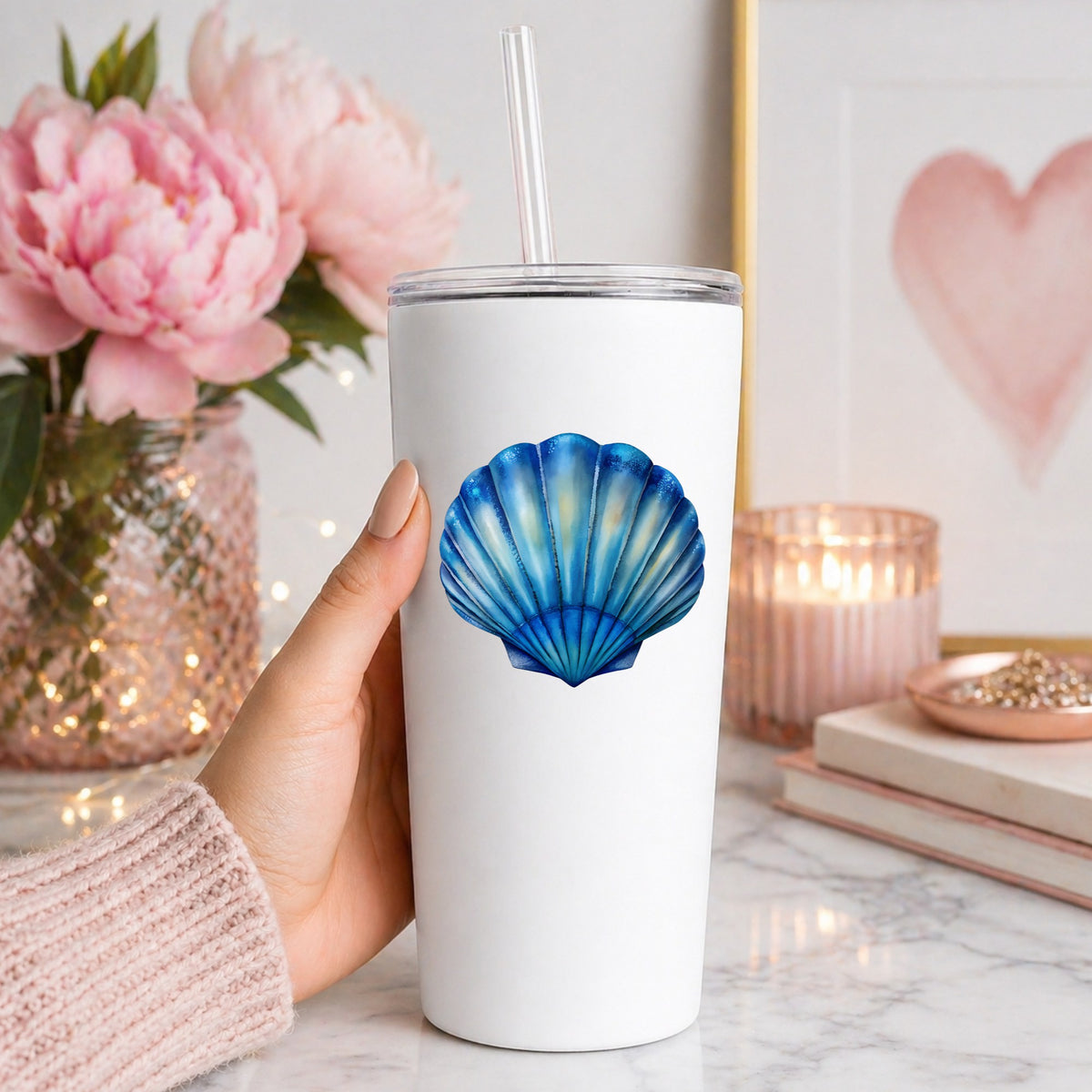 Blue Scallop Seashell UV DTF sticker applied to a white straw tumbler beside pink peonies