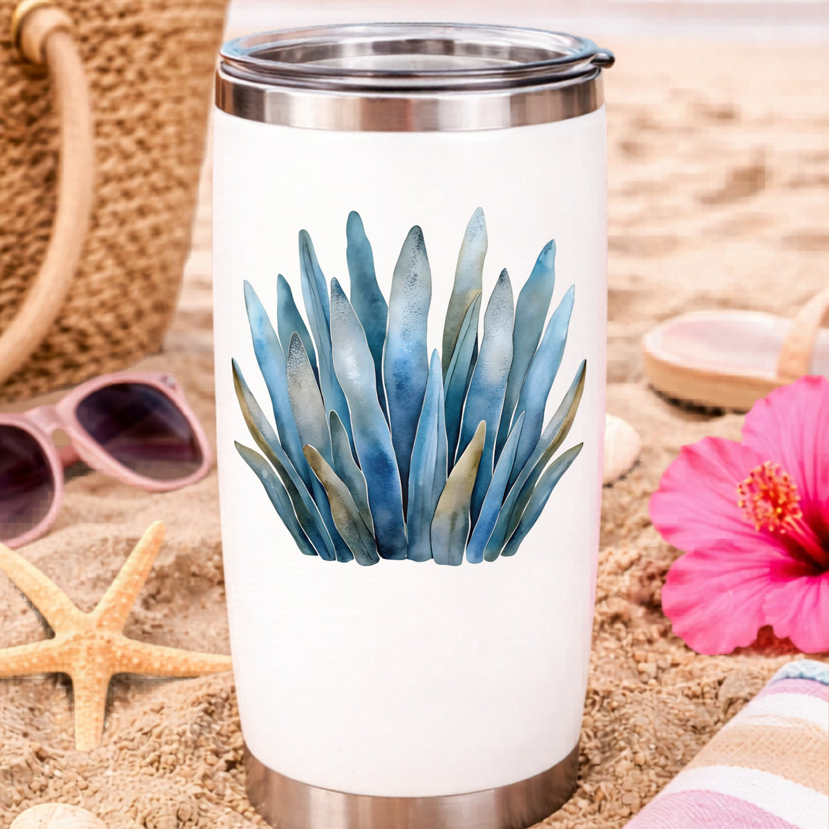 Blue Coastal Sea Grass UV DTF sticker applied to a white travel tumbler on beach sand