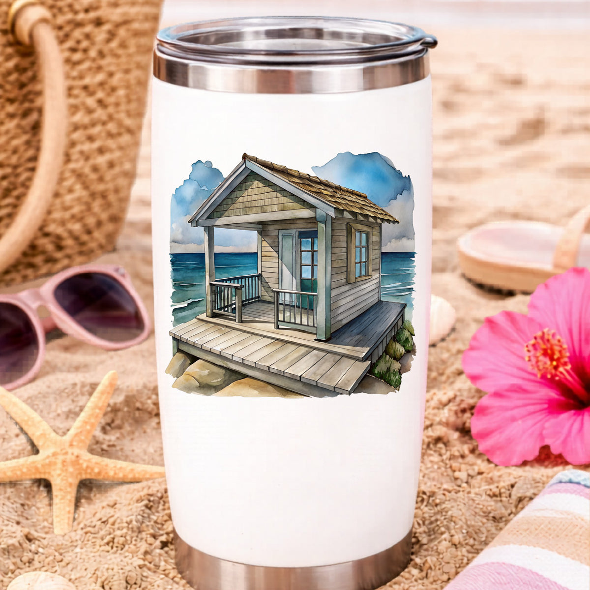 Beach Cottage Porch Ocean View UV DTF sticker applied to a white travel tumbler on beach sand