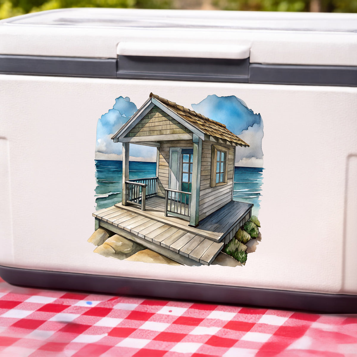 Beach Cottage Porch Ocean View UV DTF sticker applied to a white cooler on a red gingham cloth