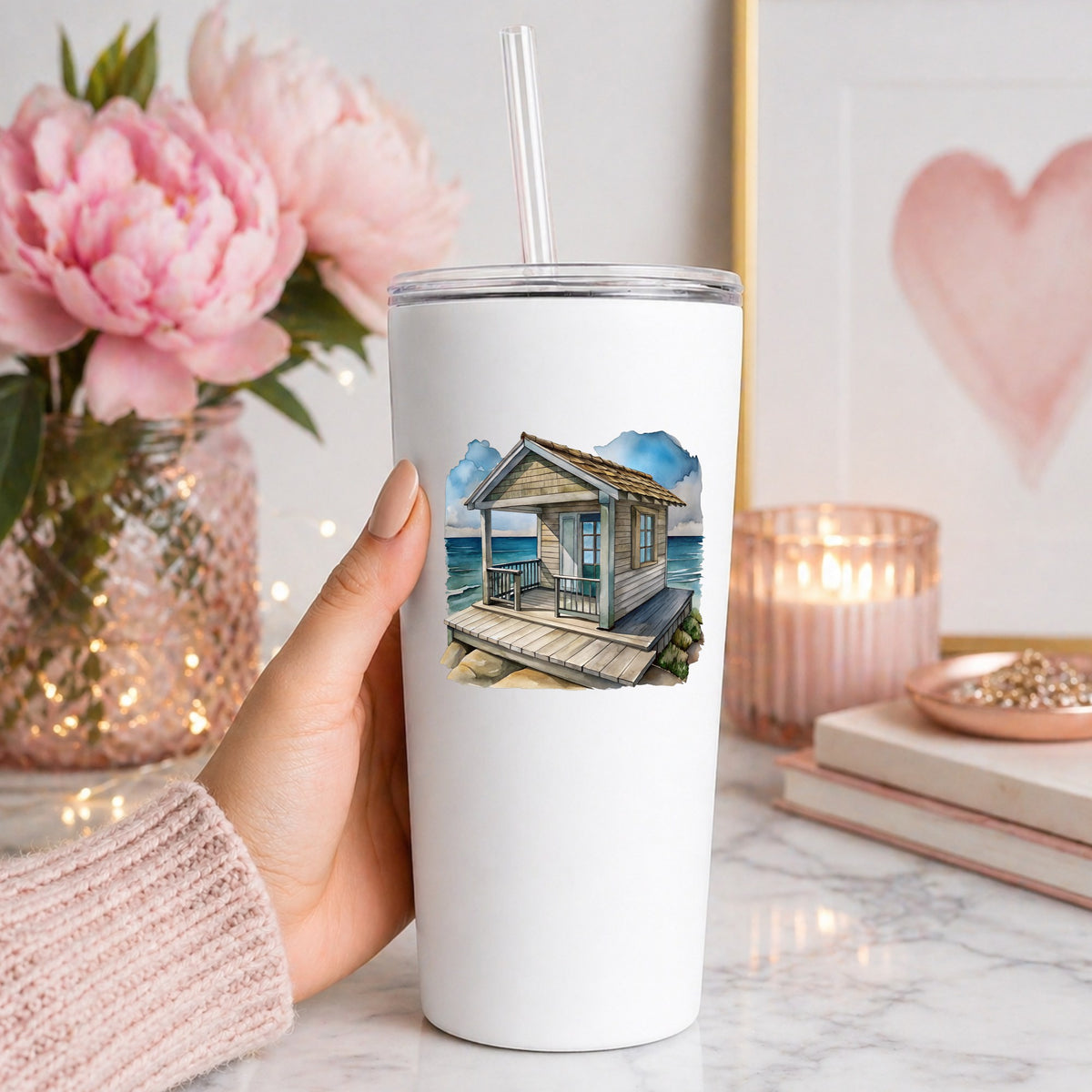 Beach Cottage Porch Ocean View UV DTF sticker applied to a white straw tumbler beside pink peonies