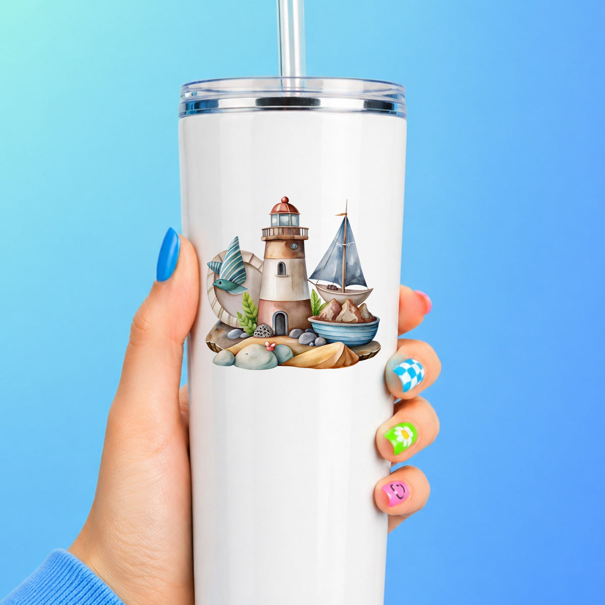 Lighthouse Sailboat Seaside Scene UV DTF sticker applied to a white straw tumbler on a blue background