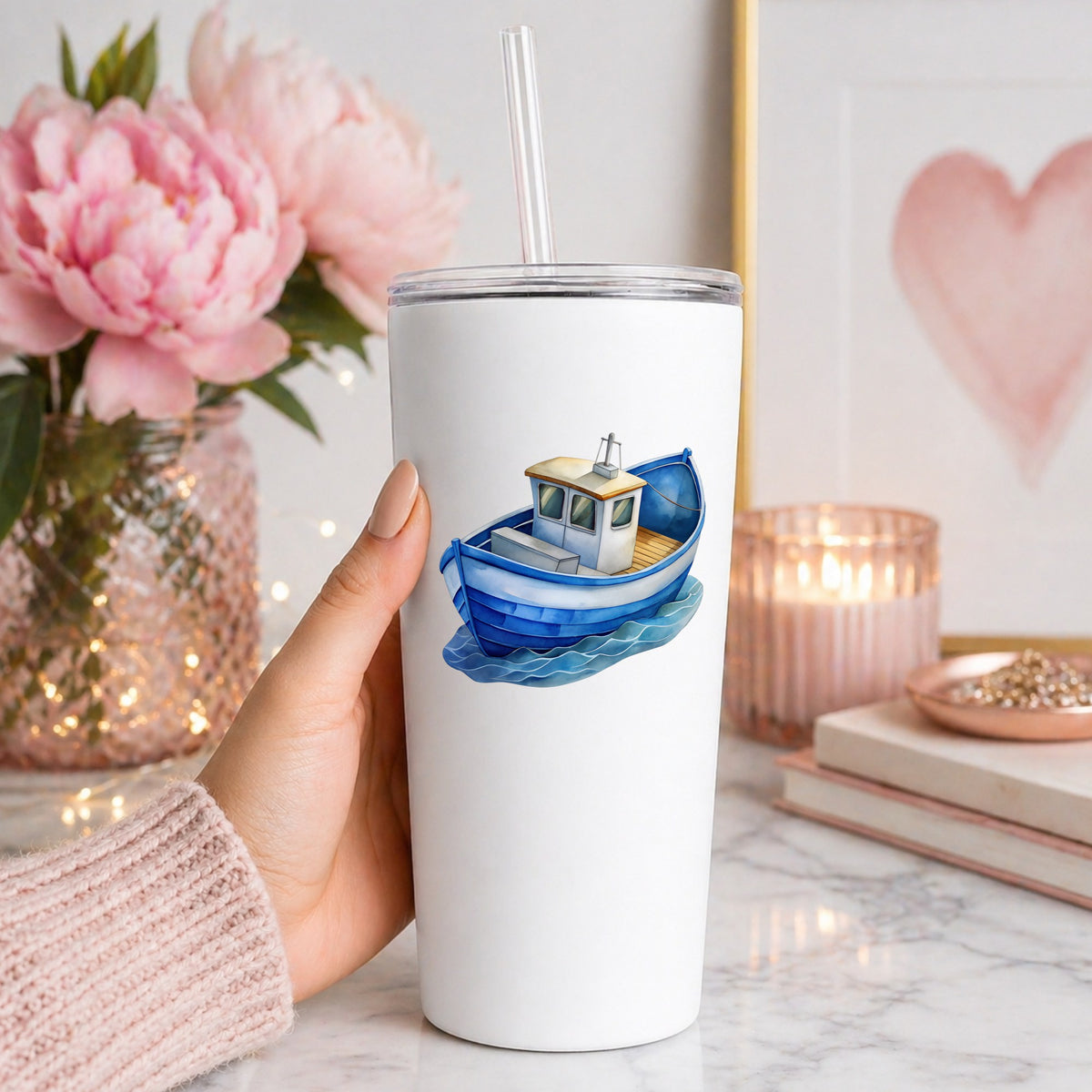 Blue Fishing Boat On Waves UV DTF sticker applied to a white straw tumbler beside pink peonies