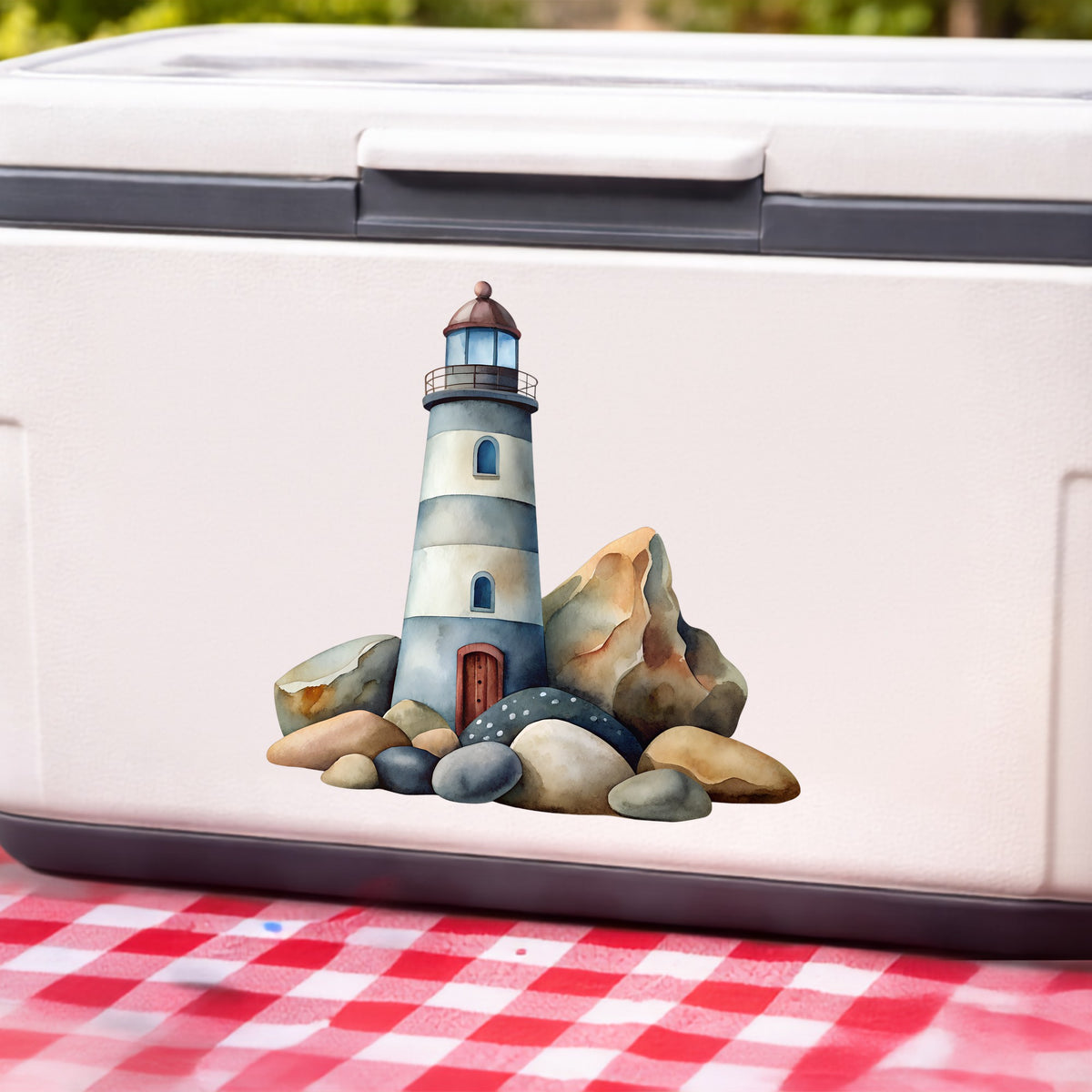 Lighthouse On Rocky Shore UV DTF sticker applied to a white cooler on a red gingham cloth