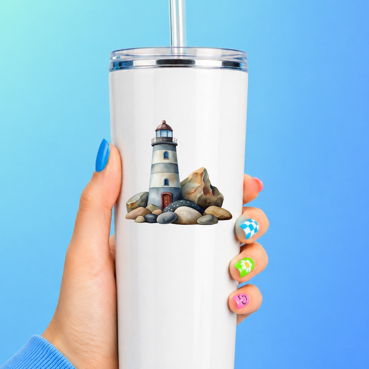 Lighthouse On Rocky Shore UV DTF sticker applied to a white straw tumbler on a blue background