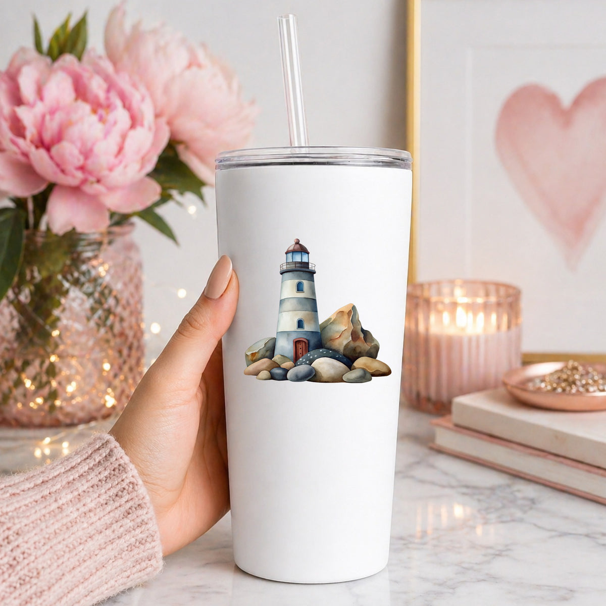 Lighthouse On Rocky Shore UV DTF sticker applied to a white straw tumbler beside pink peonies